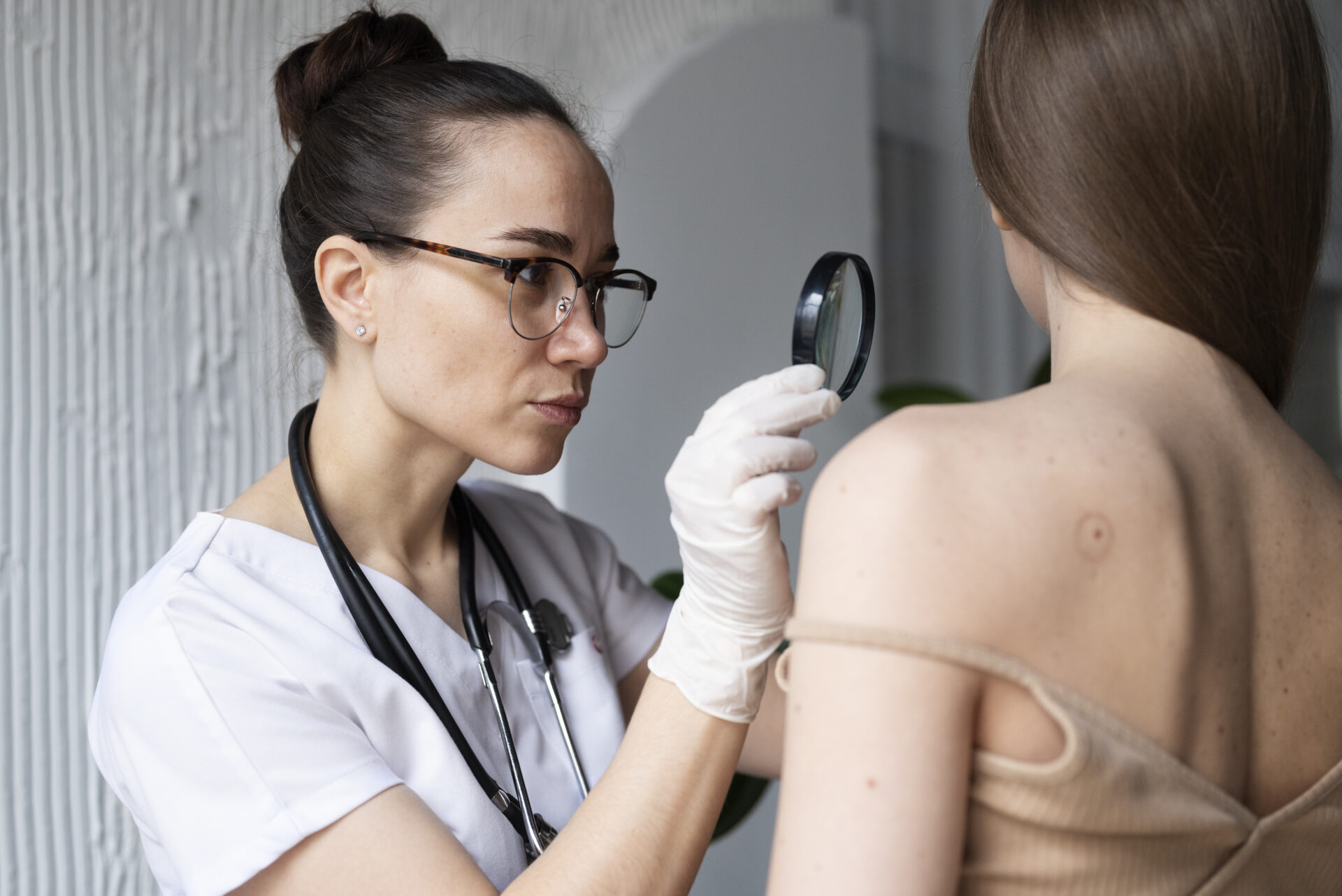 medico-femminile-che-diagnostica-un-melanoma-sul-corpo-di-una-paziente-di-sesso-femminile (1)